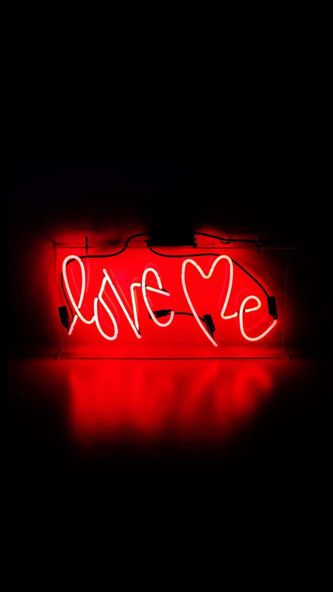 En rød neon skilt med ordet 'elsk mig' Wallpaper