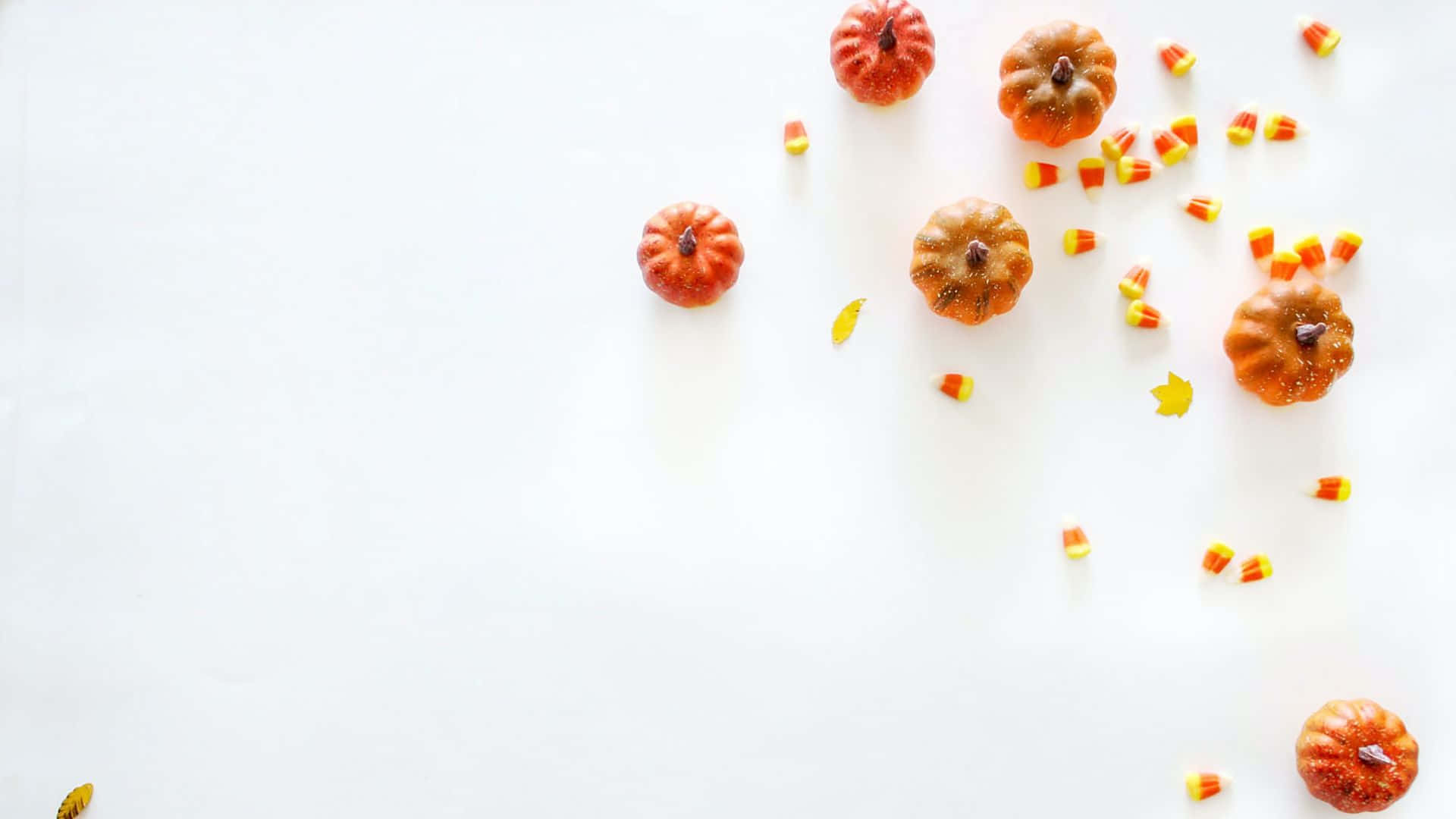 A White Background With Candy Corns And Pumpkins