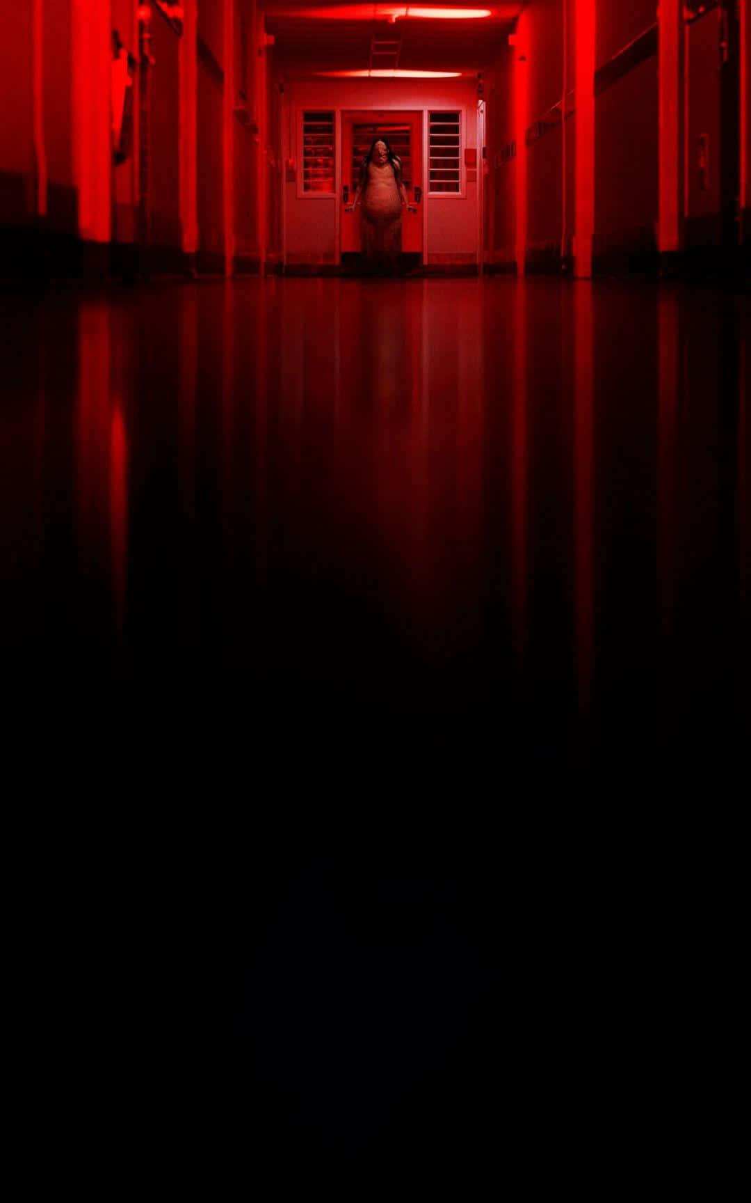 A Hallway With Red Lights And A Person In The Middle Wallpaper