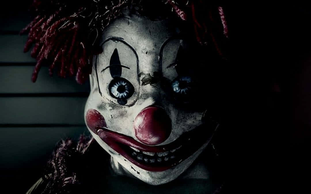 A Clown Mask With Red Hair And A Scary Face Wallpaper