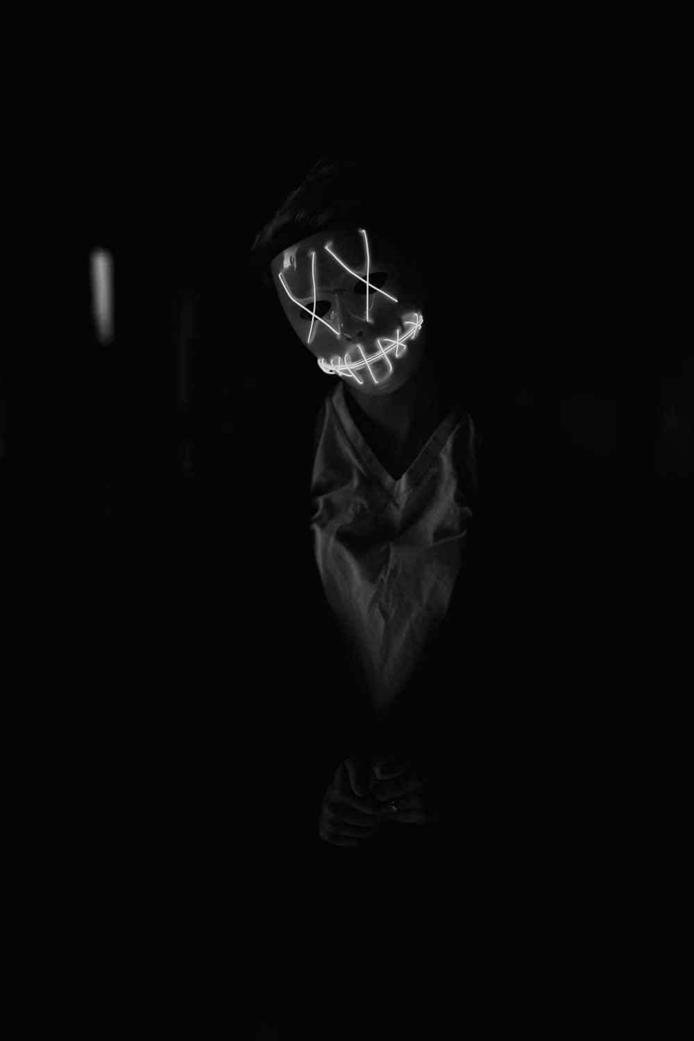 Umafoto Em Preto E Branco De Uma Pessoa Usando Máscara. Papel de Parede