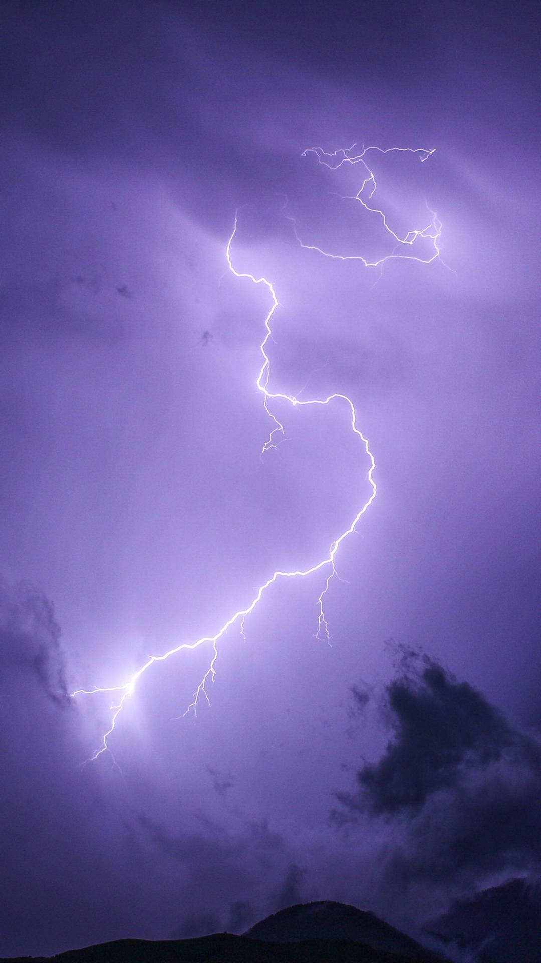 Lightning Strikes Over A Purple Sky With Clouds Wallpaper