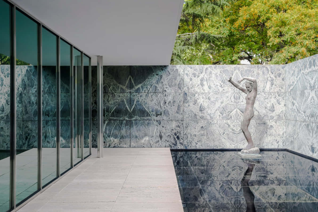 A House With A Large Glass Wall And A Statue