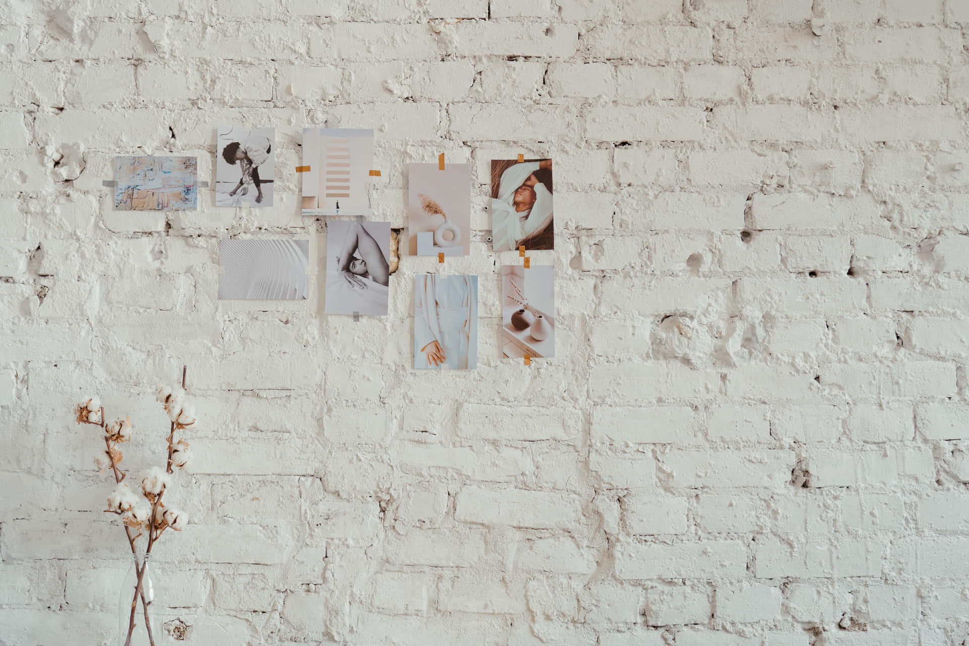 Eineweiße Backsteinwand Mit Einer Vase Und Einigen Fotos Wallpaper