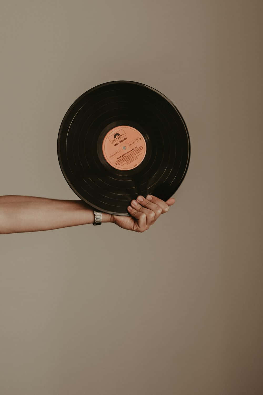 A Woman Holding A Record In Her Hand