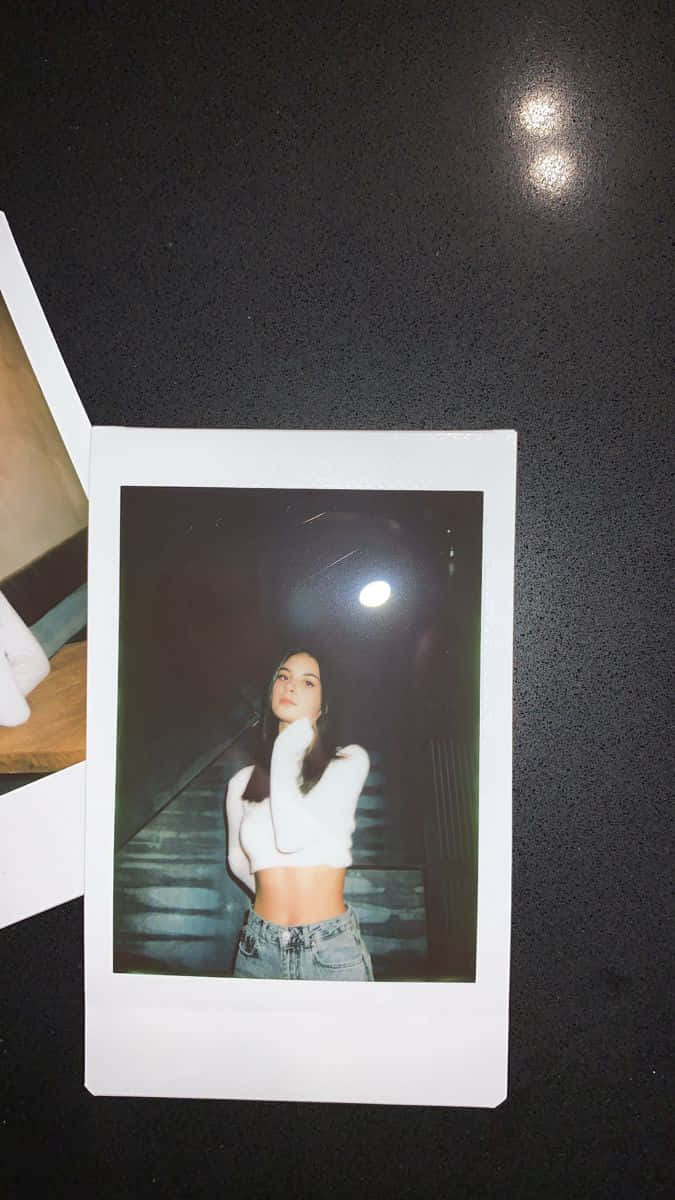 A Woman Is Standing Next To Two Polaroid Photos