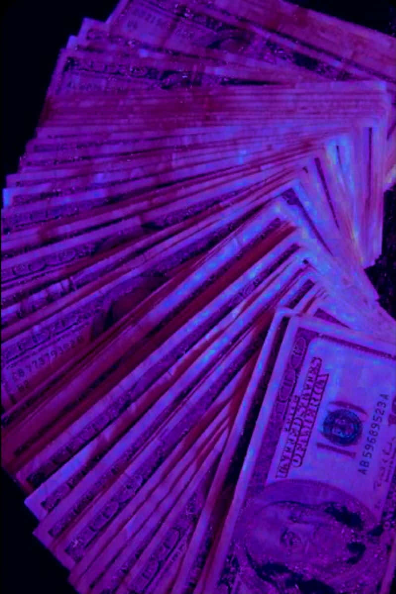 A Pile Of Money With Purple Lights On It Wallpaper
