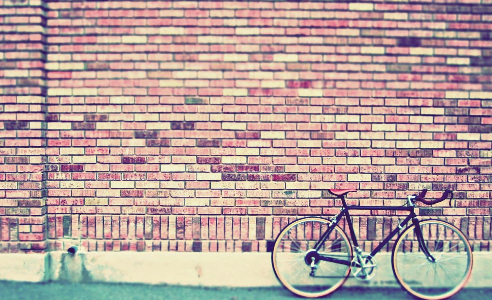 En cykel stående op ad en mur af mursten Wallpaper