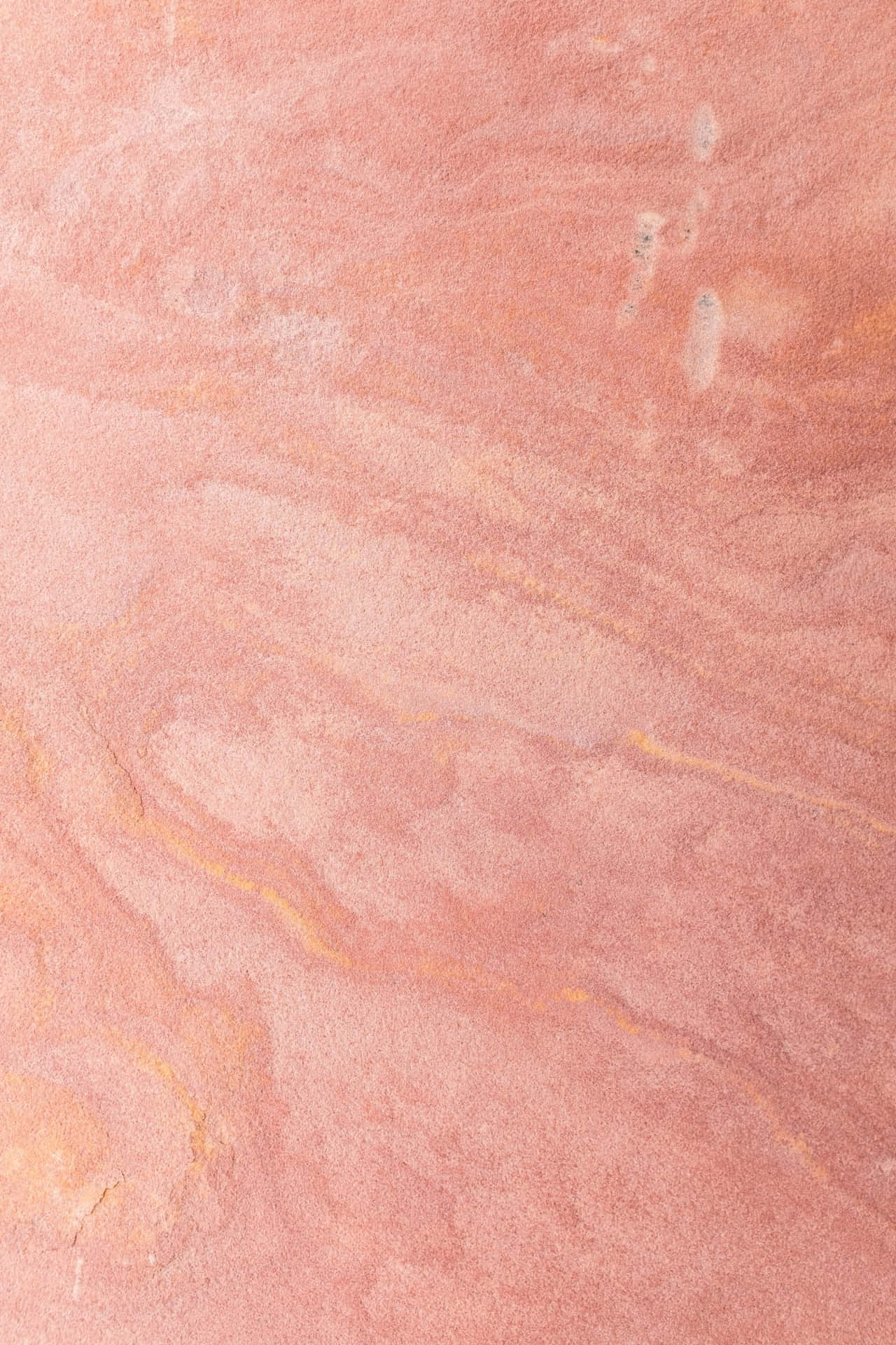 En pink marmor overflade med et gult og orangemønster.