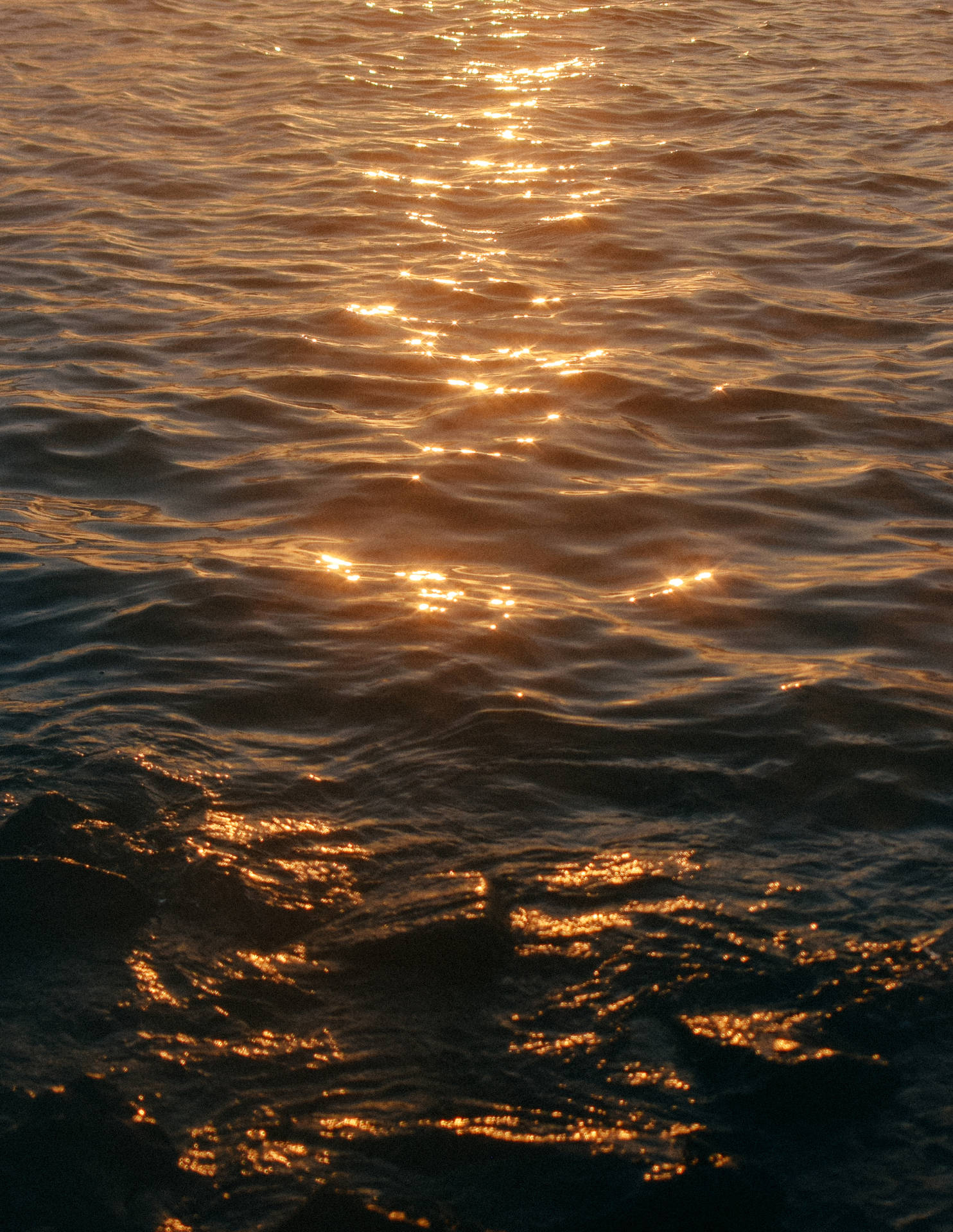 Aesthetic wallpaper of sea waves and sunlight reflection on ocean water. 