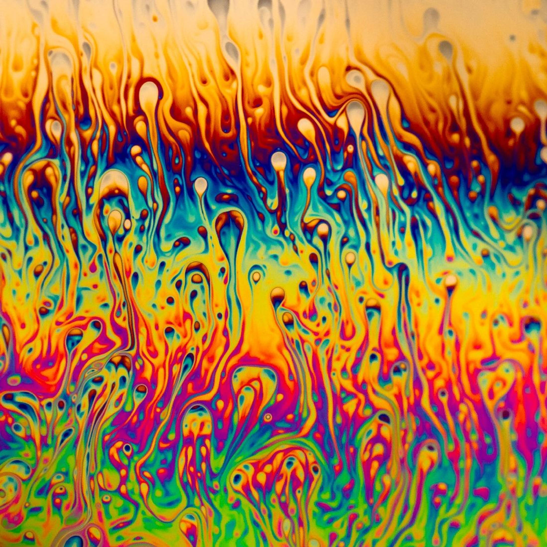 En farverig vanddråbe på en glasagtig overflade Wallpaper