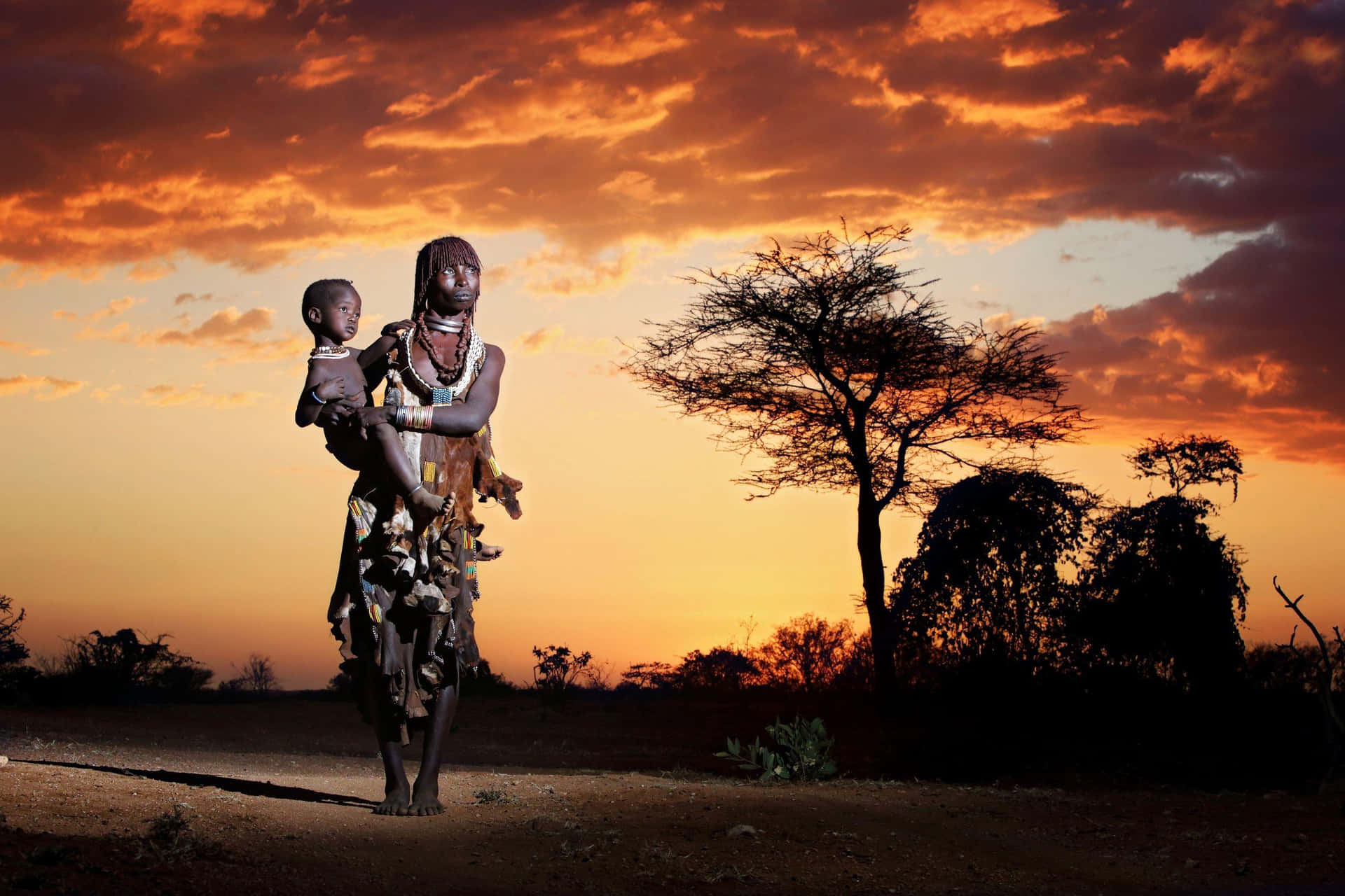 En statue af en kvinde og barn stående i ørkenen. Wallpaper