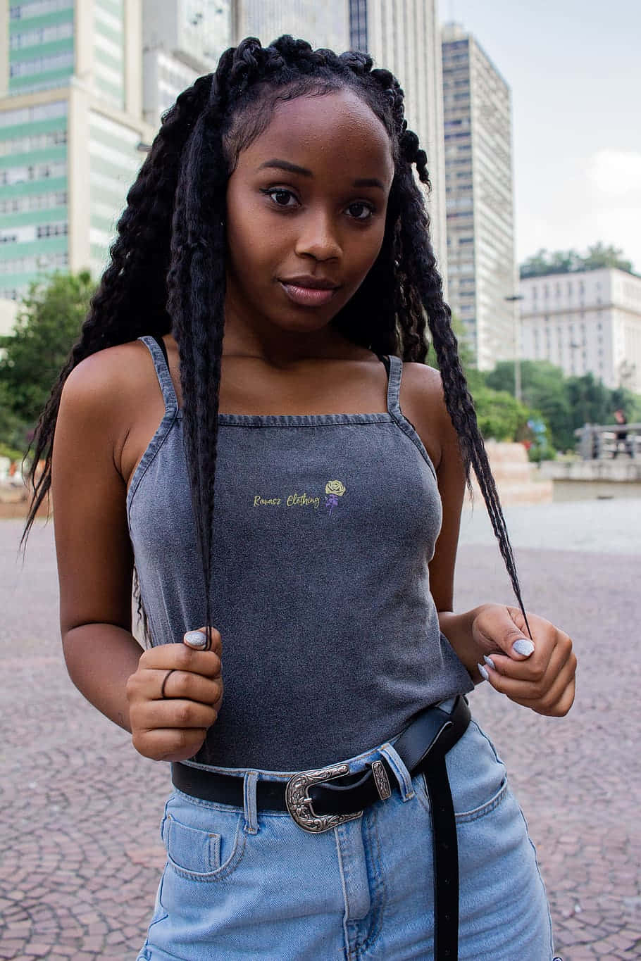 A Young Woman Wearing A Gray Tank Top And Jeans