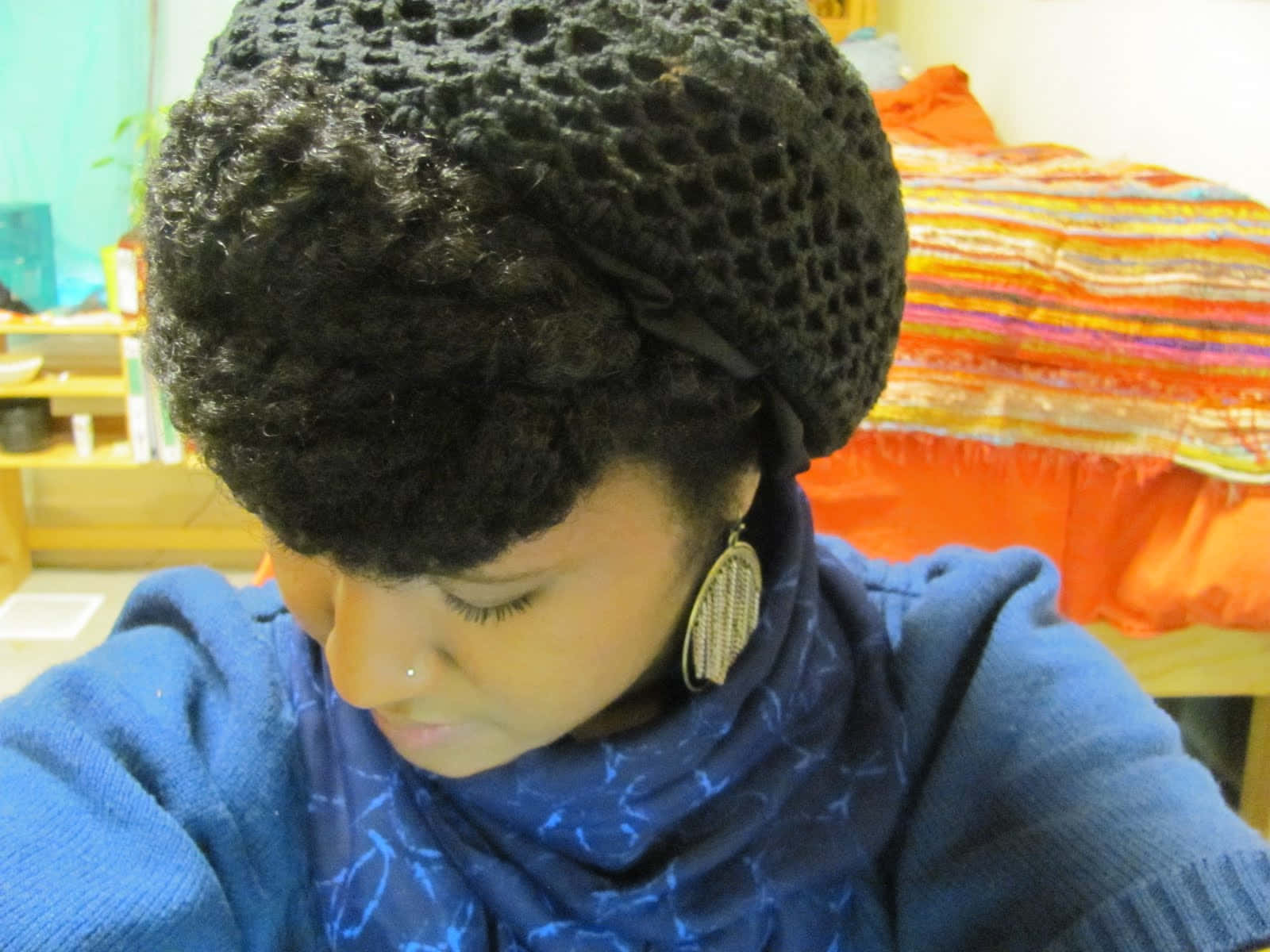 A Woman Wearing A Black Crochet Hat And Scarf