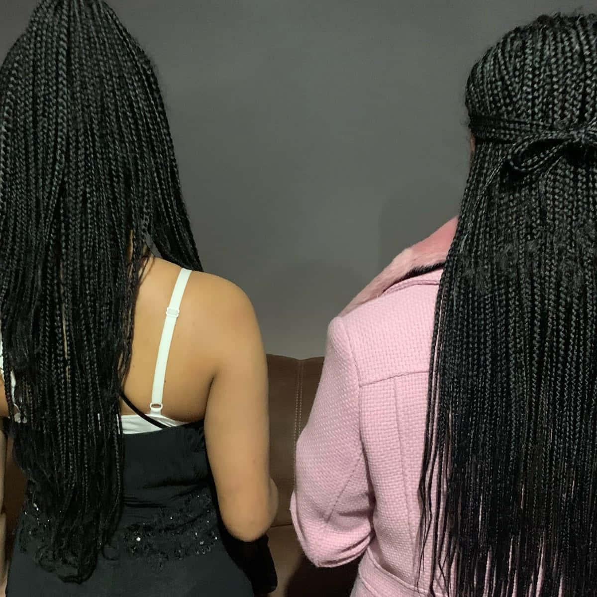 Two Women With Long Braids Standing Next To Each Other