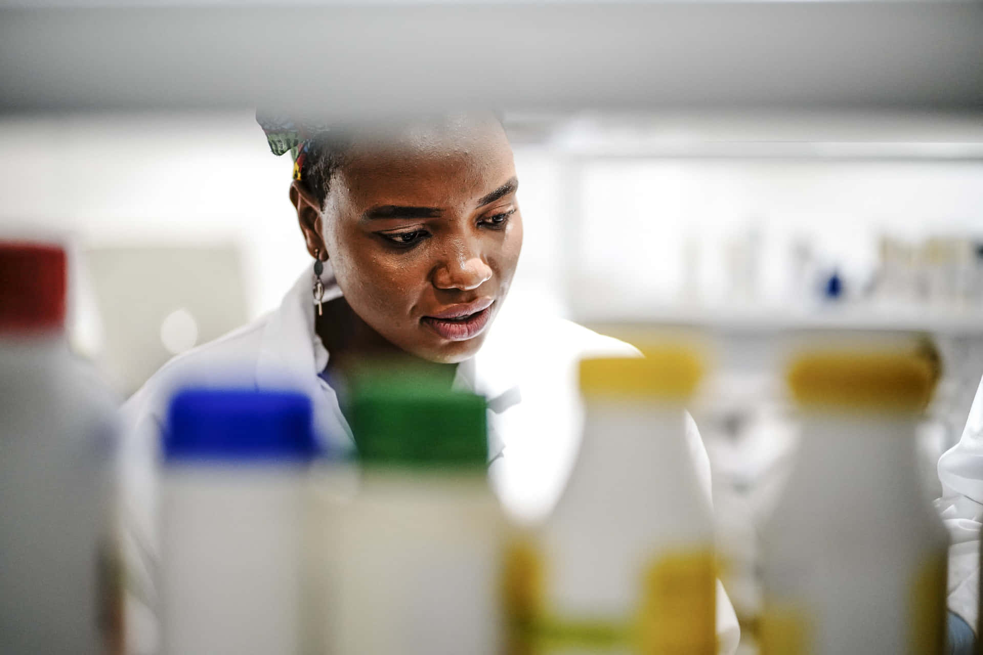 A Woman In A Lab Looking At Bottles