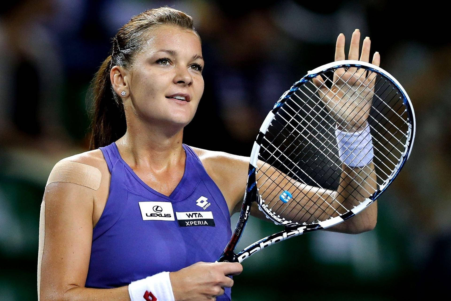 Agnieszka Radwanska in action with her racket during a tennis match. Wallpaper