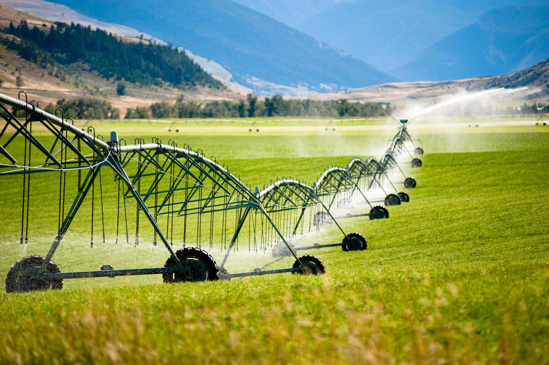 Irrigation Systems In A Field With Mountains In The Background