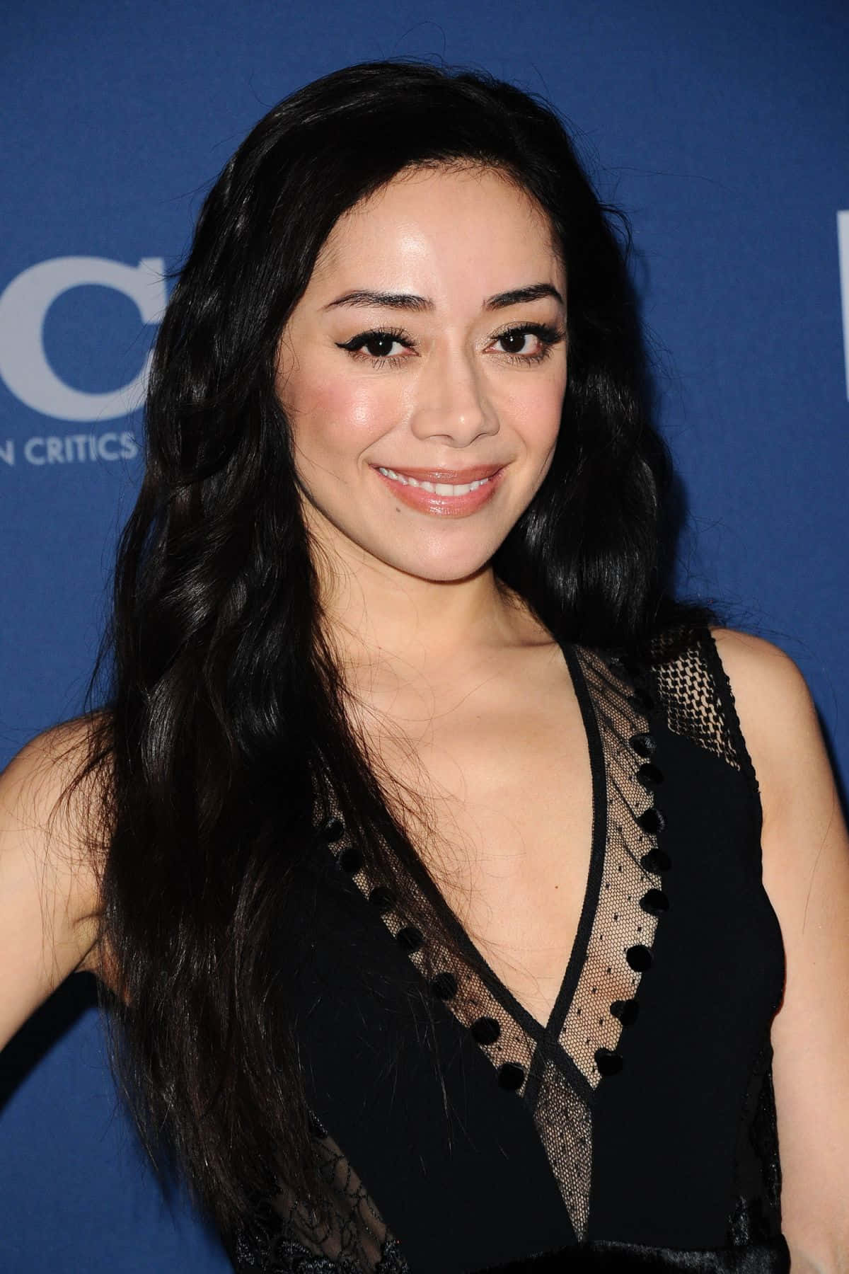 Aimee Garcia Glimlacht Elegant In Een Bloemenjurk Achtergrond