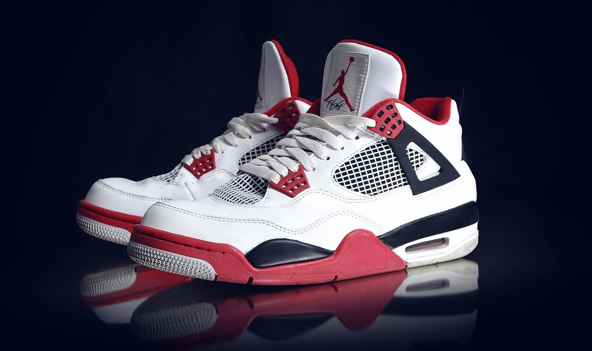 Et par hvide og røde Air Jordan 4 sneakers Wallpaper