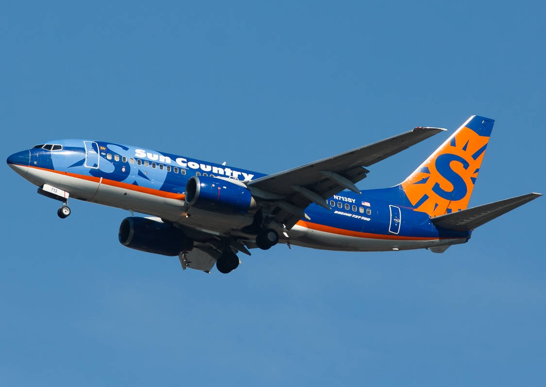 Flyvninger fra Sun Country Airlines kører gennem blå himmel Wallpaper