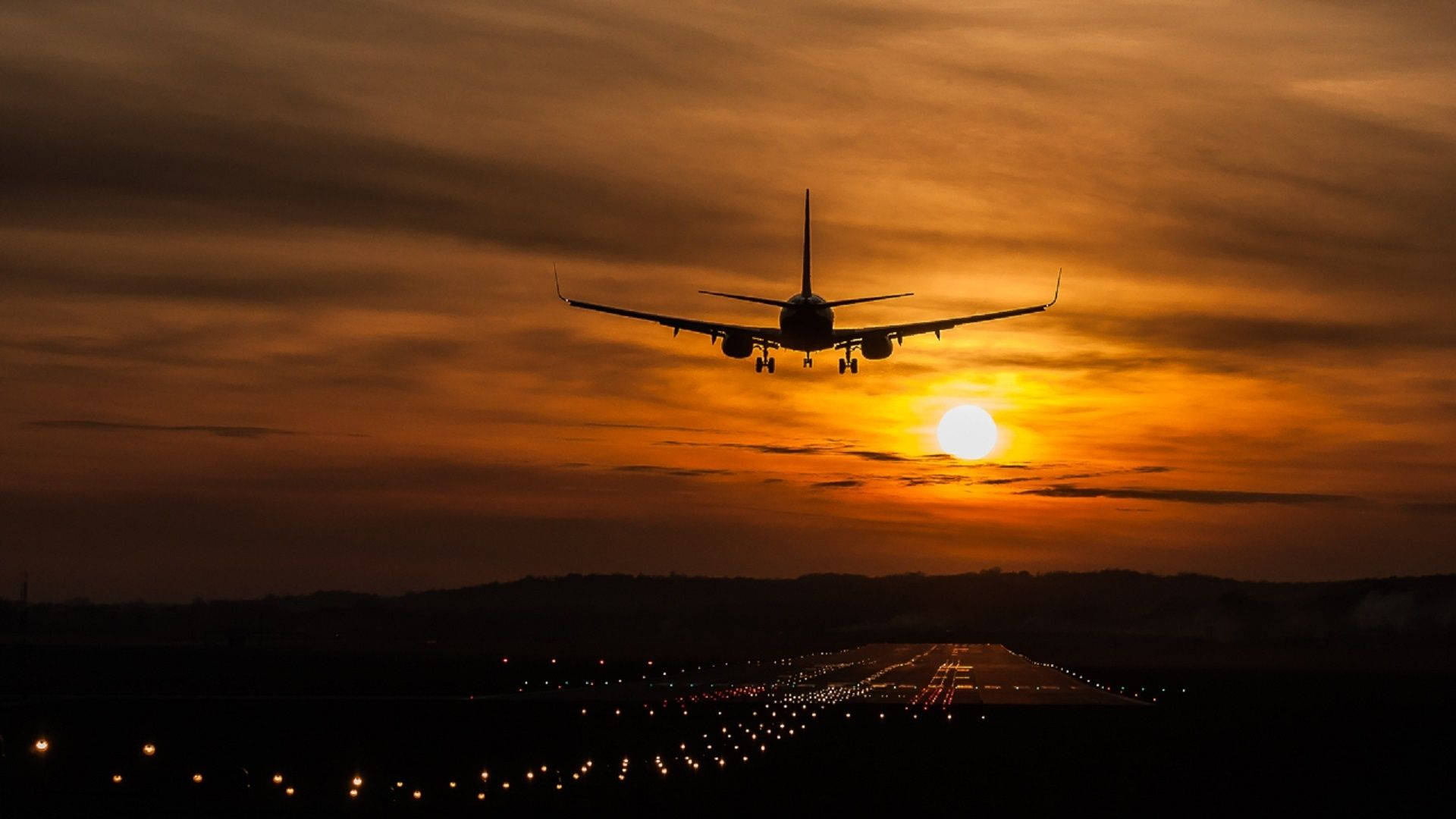 Flugzeugüber Der Start- Und Landebahn Bei Sonnenaufgang Wallpaper