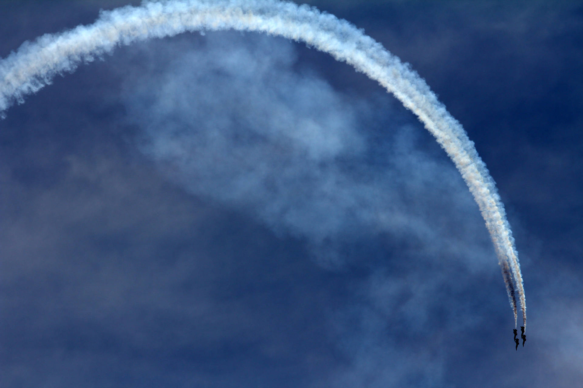 An Aerial Display of Aerobatic Stunts by an Airplane Wallpaper