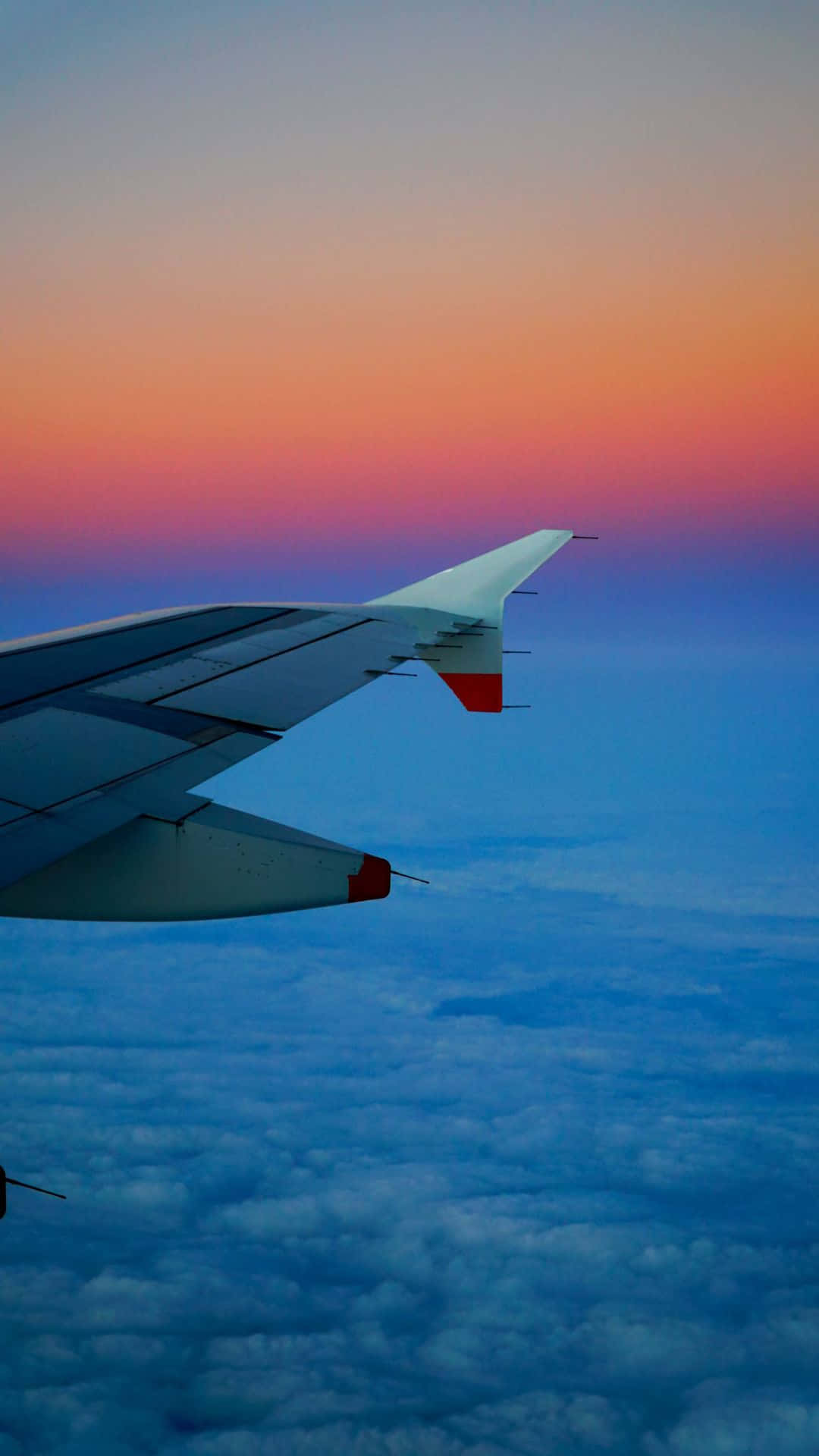 Flygplansfönstermed Solnedgångsbakgrund