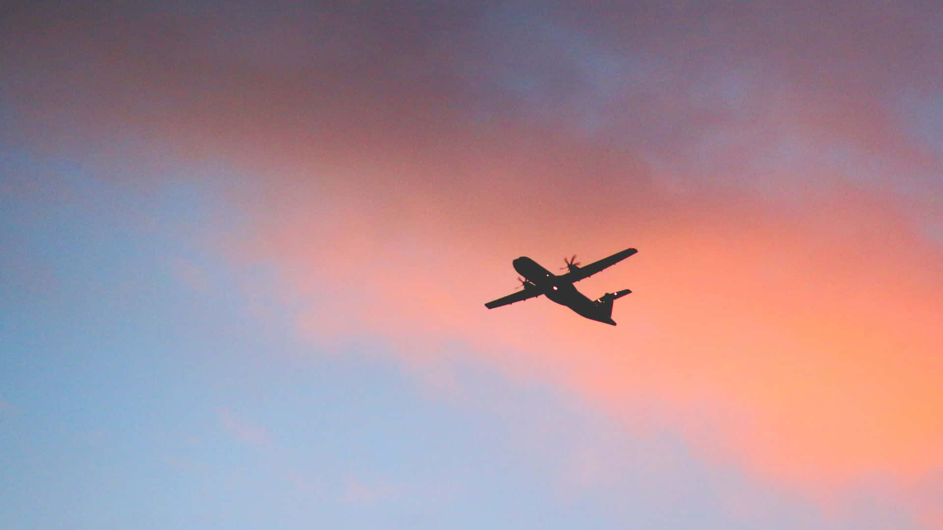 Flugzeugam Himmel Mit Sonnenuntergang Im Hintergrund.