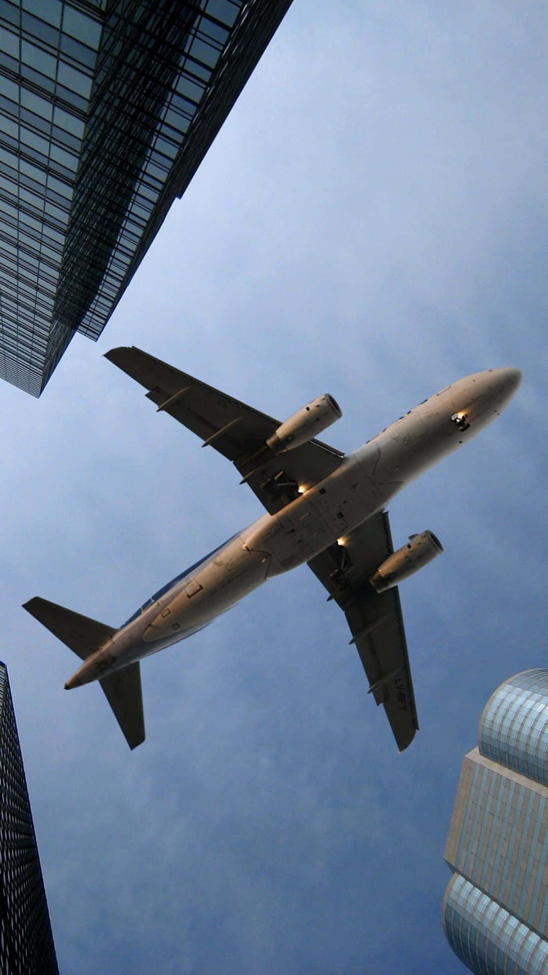 Airplane Flying Over Skyscrapers Wallpaper