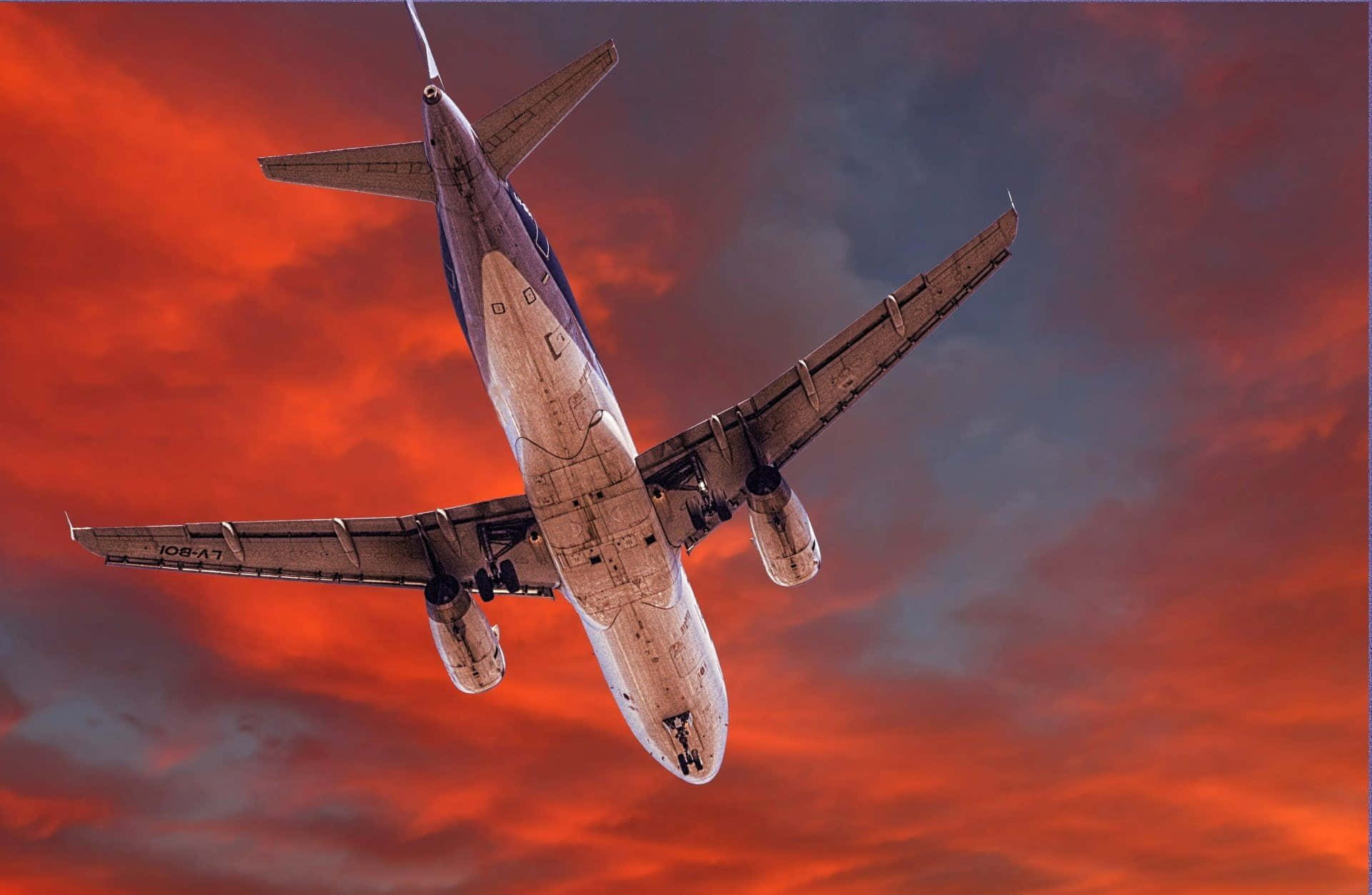 Airplane Soaring Through Sunset Sky Wallpaper