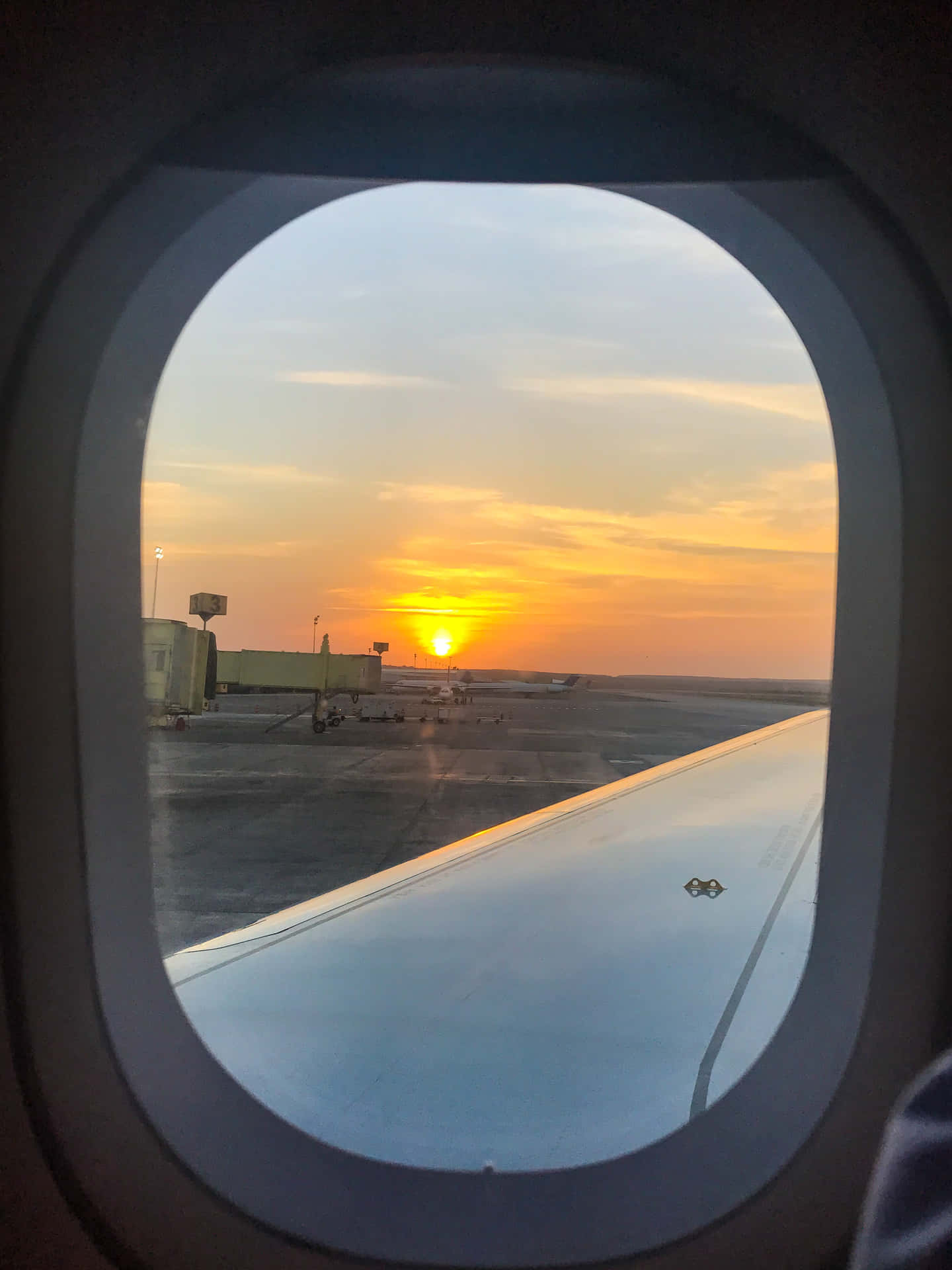 A Plane Window With A View Of The Sun Setting