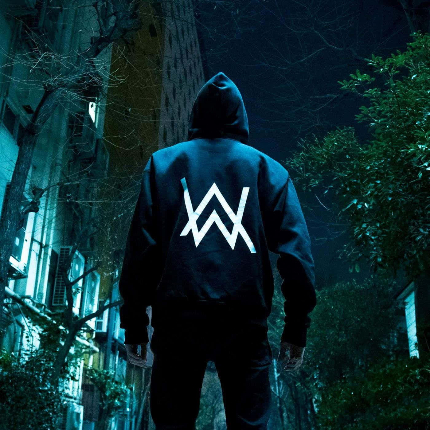 Alan Walker posing in his signature hoodie and mask
