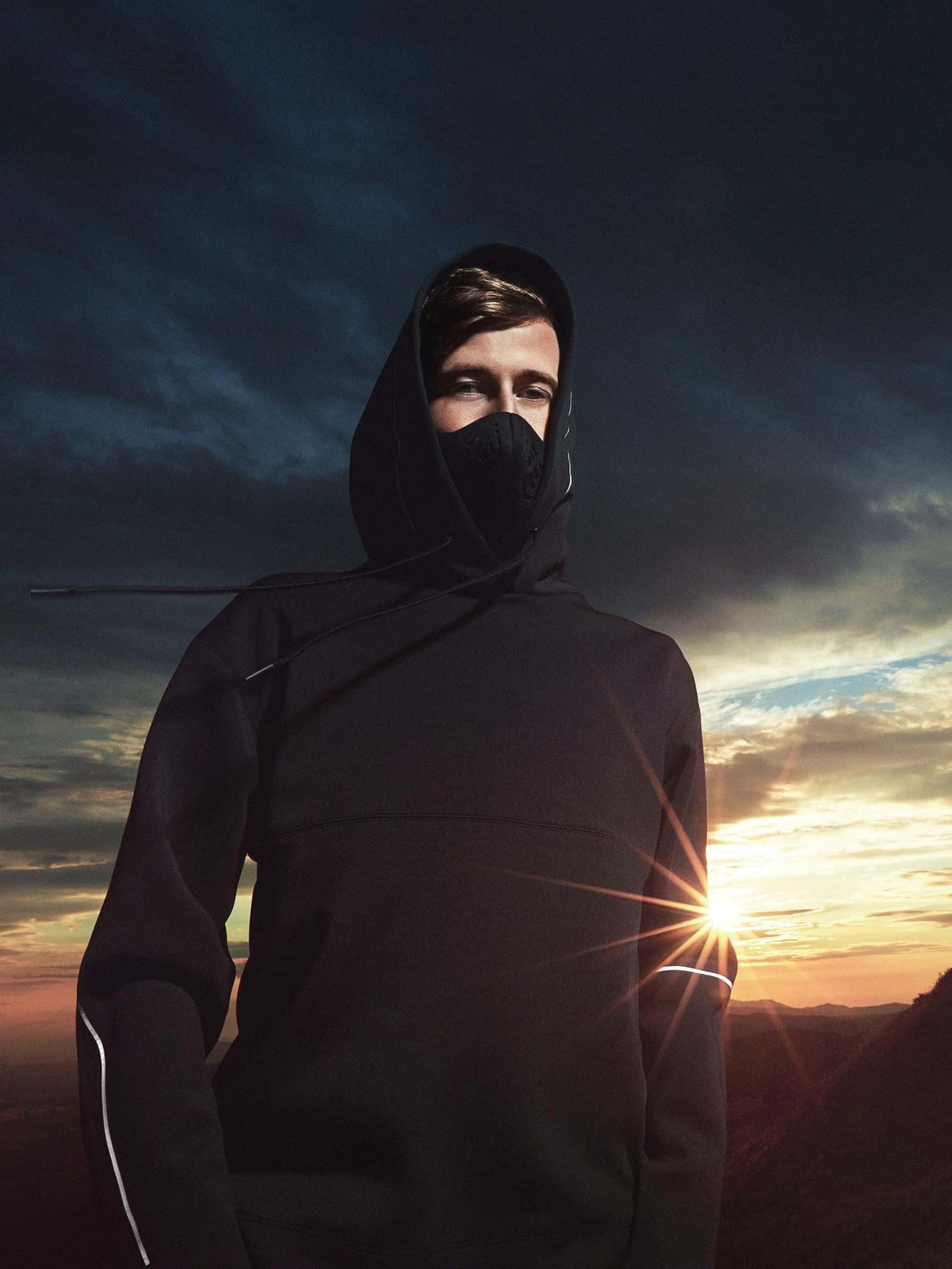 Alan Walker performing live on stage with a vibrant background