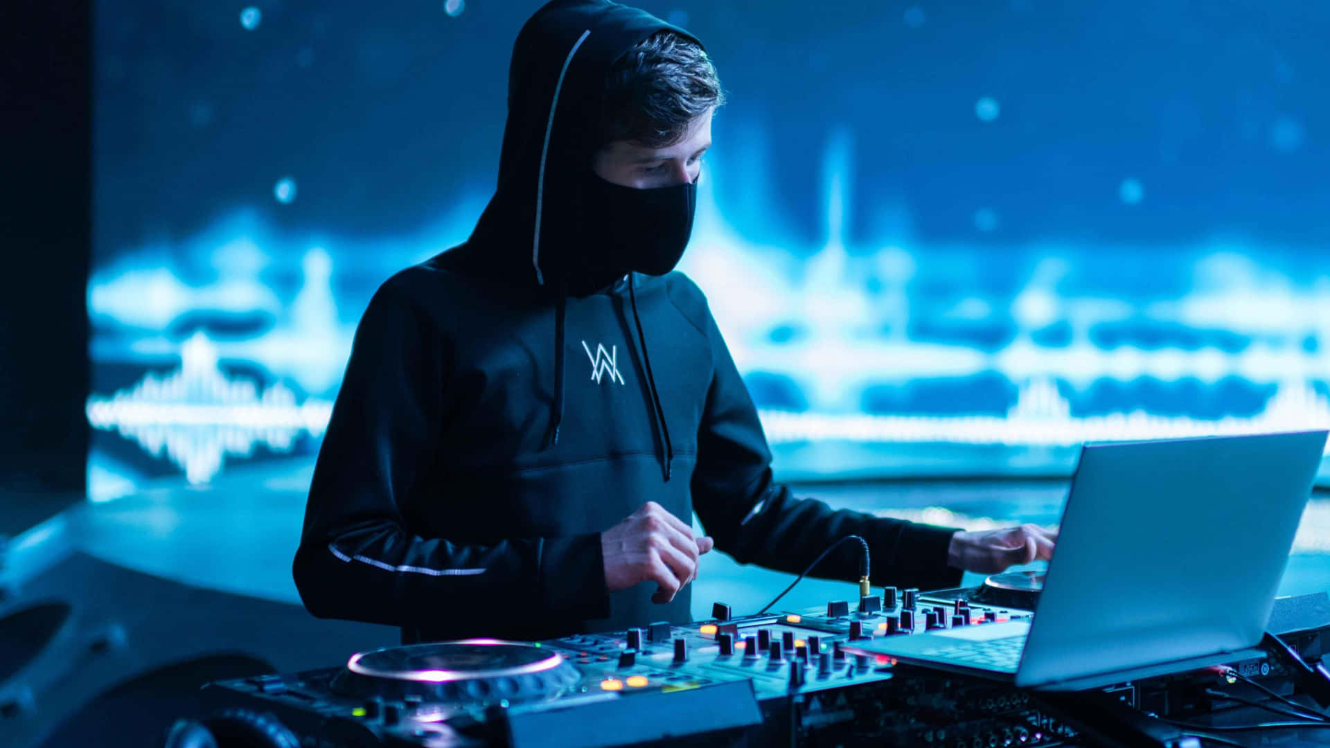 Alan Walker performing live on stage with a dynamic light show