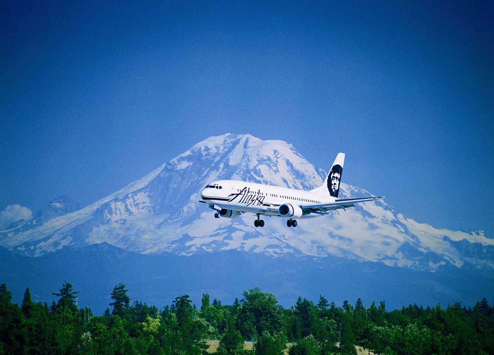 Aereodi Alaska Airlines Vicino A Una Montagna. Sfondo