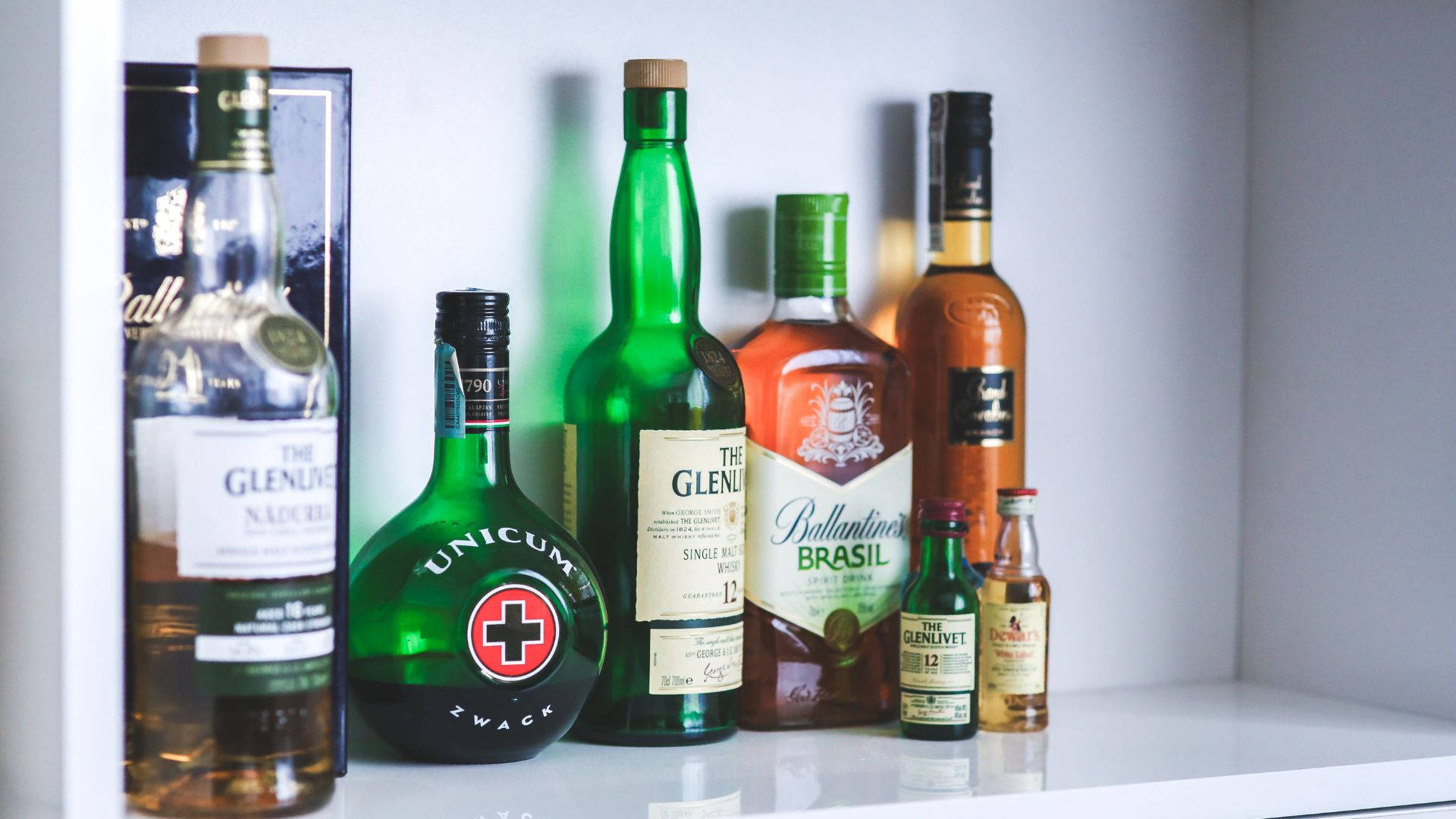 Alcohol Bottles Collection On White Shelf Picture