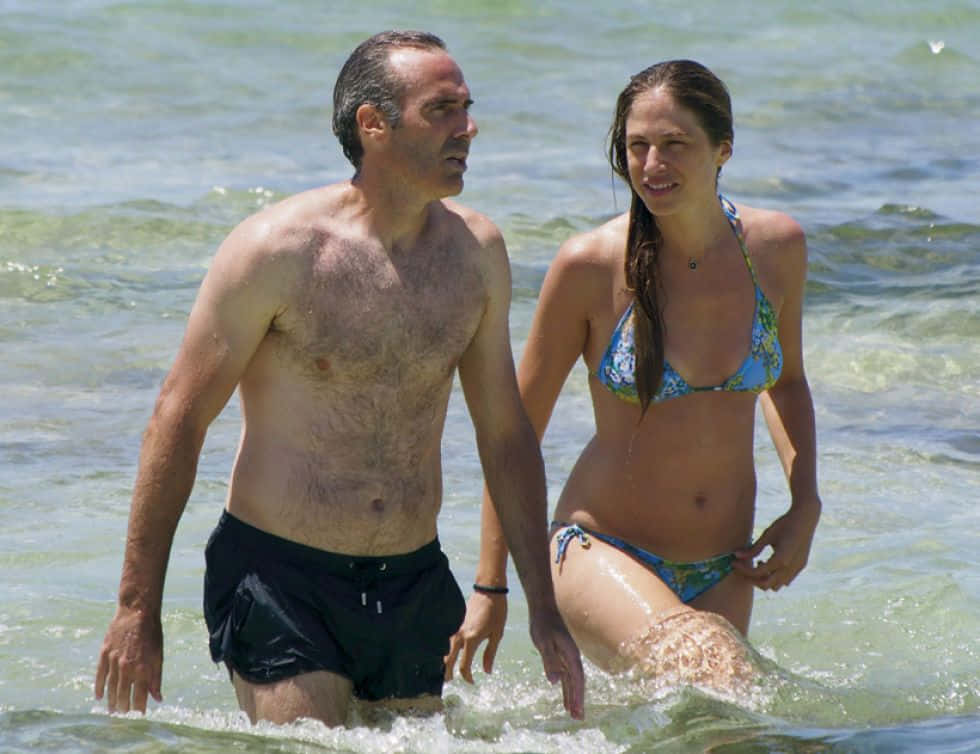 Alex Corretja Wading In Beach With Wife Wallpaper