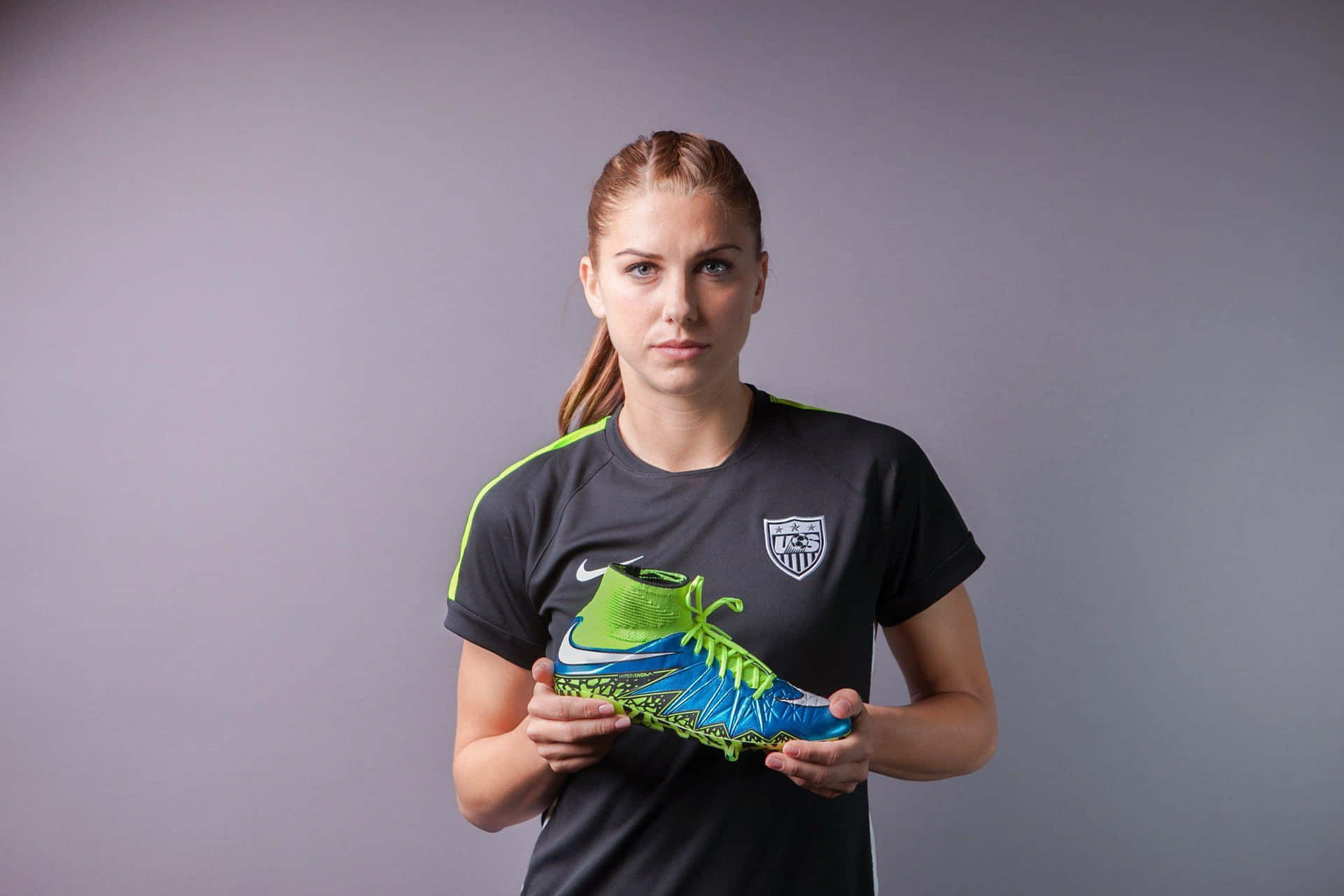 A Woman Holding A Soccer Ball And A Pair Of Shoes