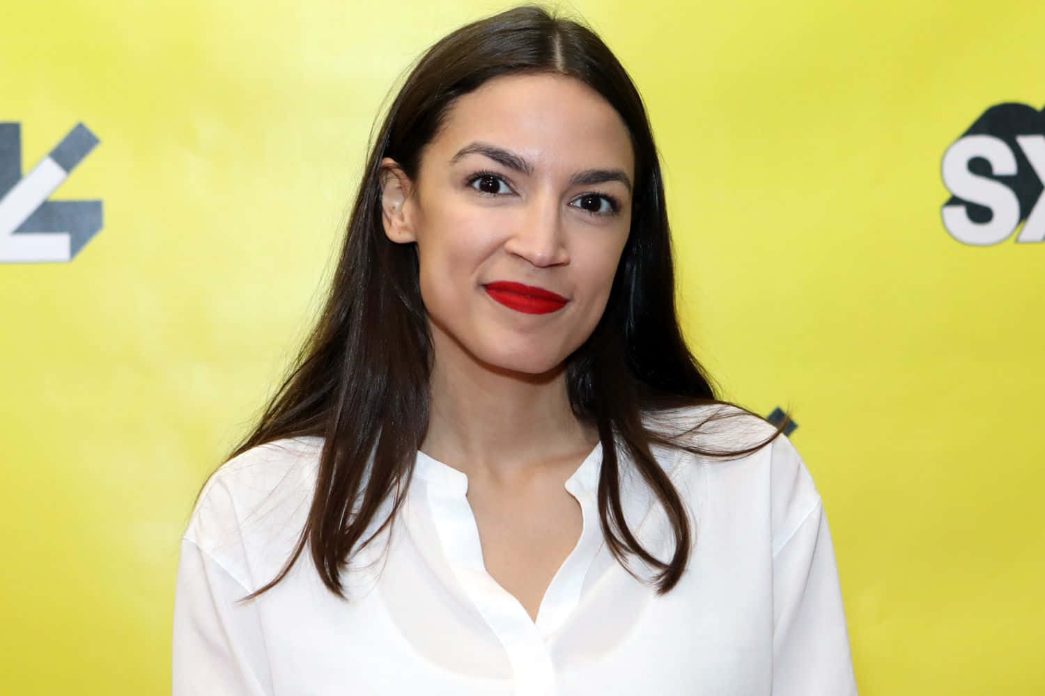 Alexandria Ocasio-Cortez, Vibrantly Posed Against a Yellow Backdrop Wallpaper