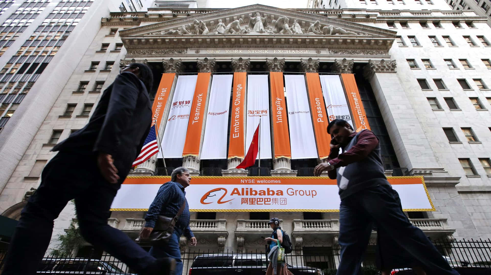 Engrupp Människor Går Förbi En Byggnad Med En Alibaba-skylt