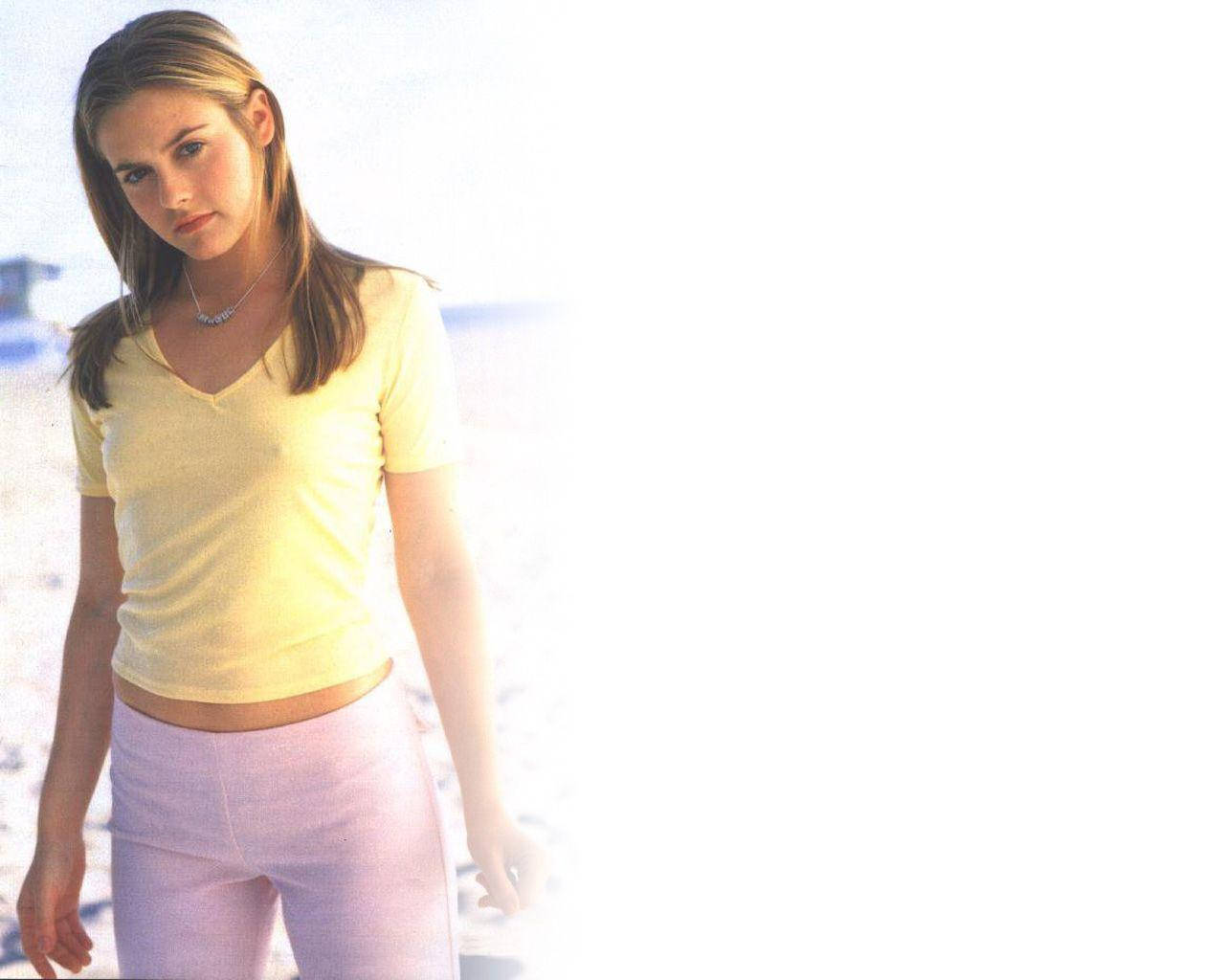 Alicia Silverstone In Simple Yellow Shirt Wallpaper