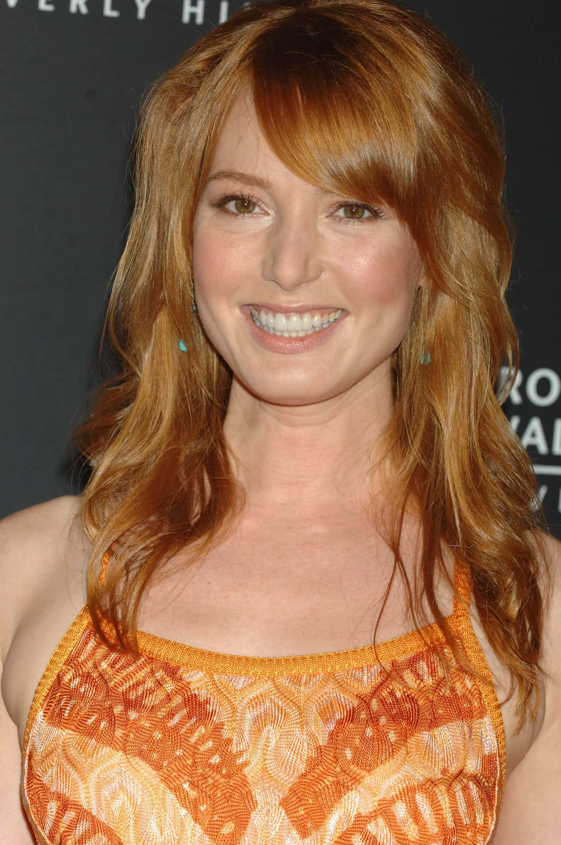 Alicia Witt striking a pose in an elegant outfit. Wallpaper