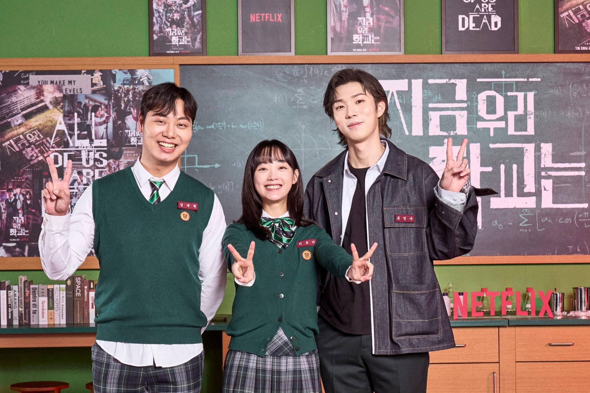 Students from 'All Of Us Are Dead' showing peace signs with a smile Wallpaper