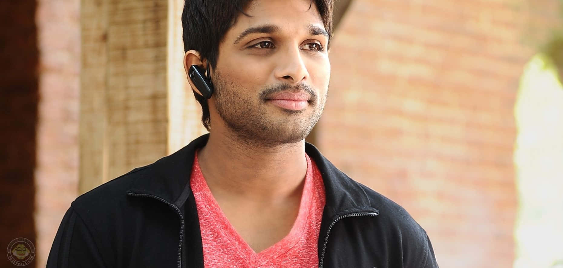 A Man Wearing A Black Jacket And Earphones
