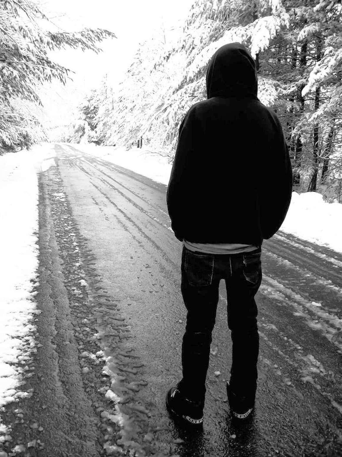 Ensampojke På En Snöig Väg Bild.