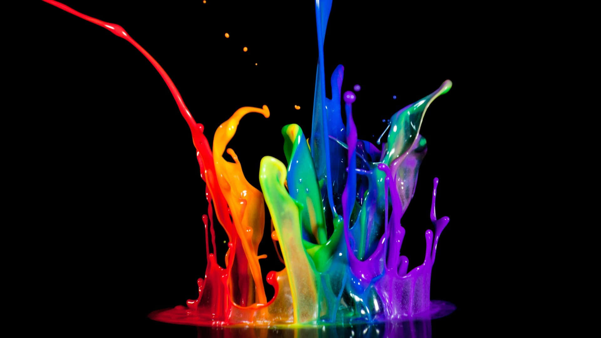 Rainbow Paint Splashing On A Black Background Wallpaper
