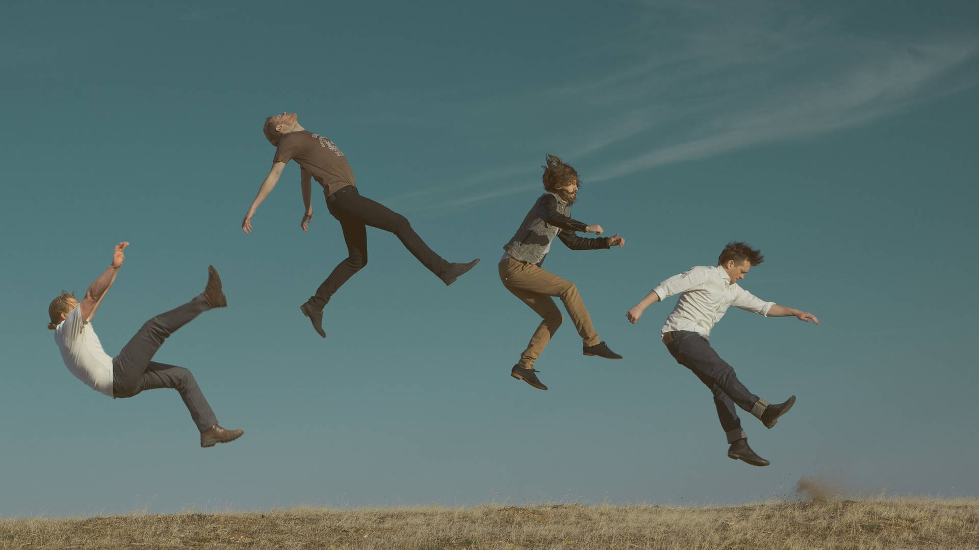 Einegruppe Von Menschen Springt In Die Luft. Wallpaper