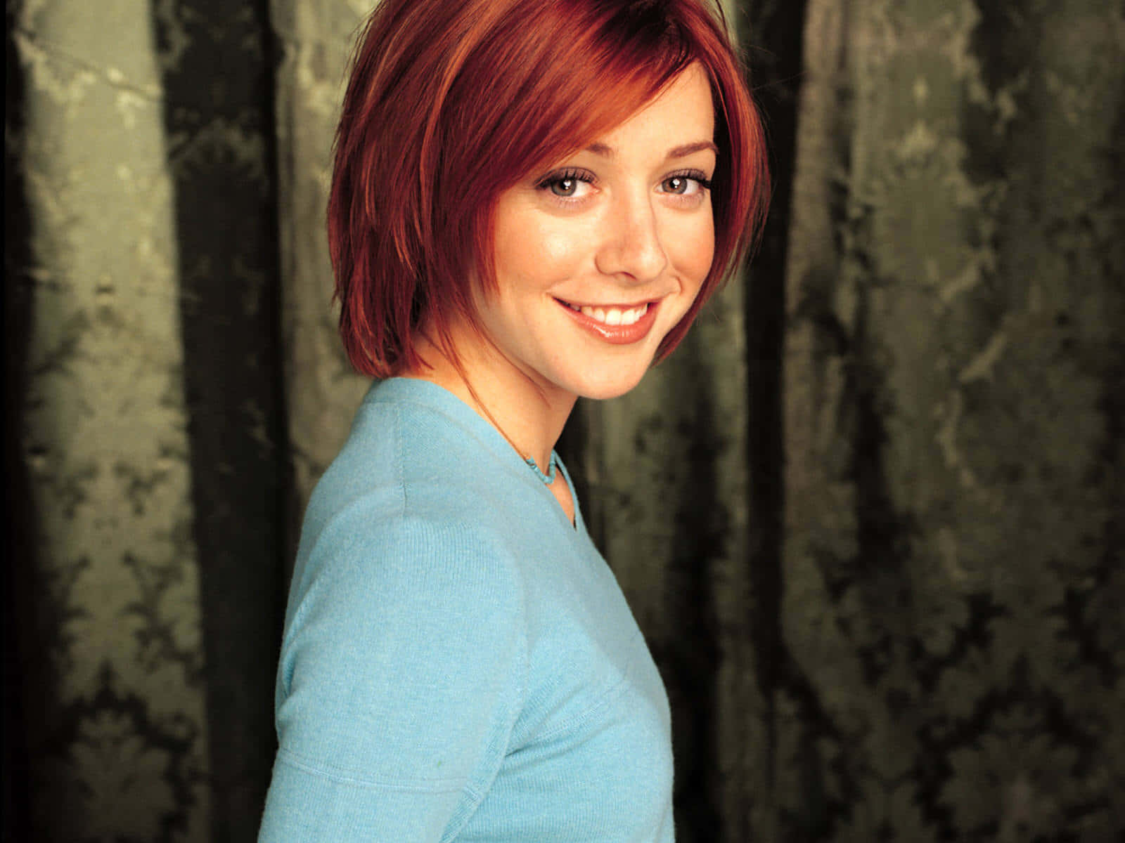 Alyson Hannigan striking a pose in a chic purple outfit Wallpaper