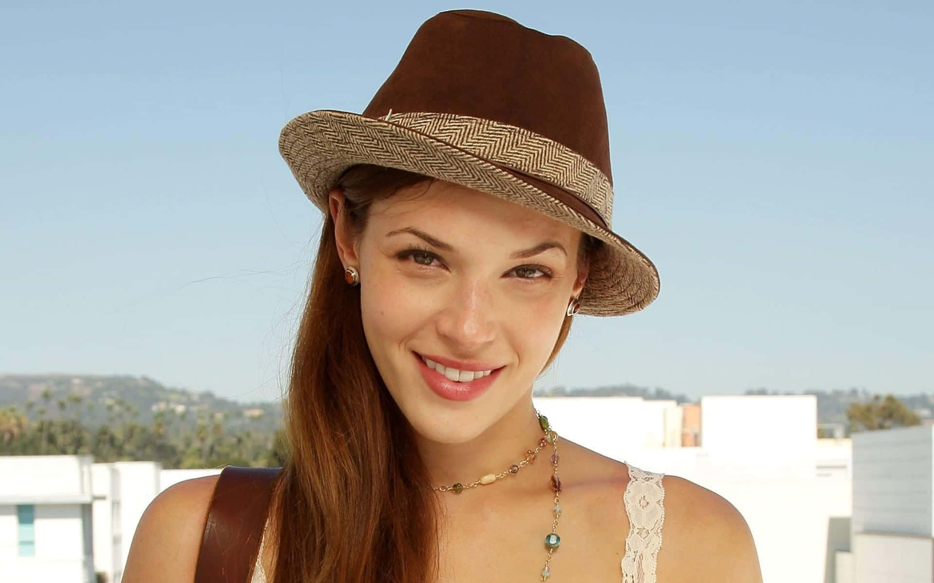 Amanda Righetti Glimlachend Met Hoed Achtergrond